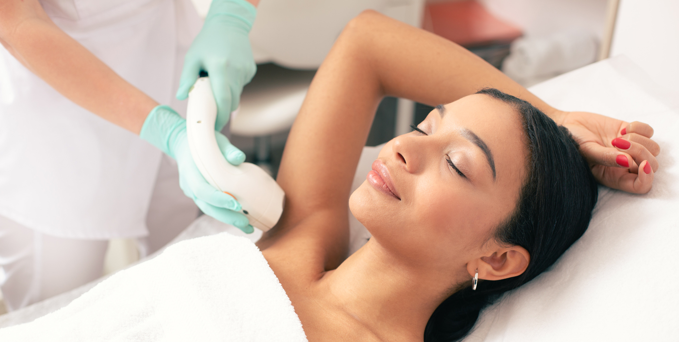 woman with arm over head getting laser hair removal in armpit