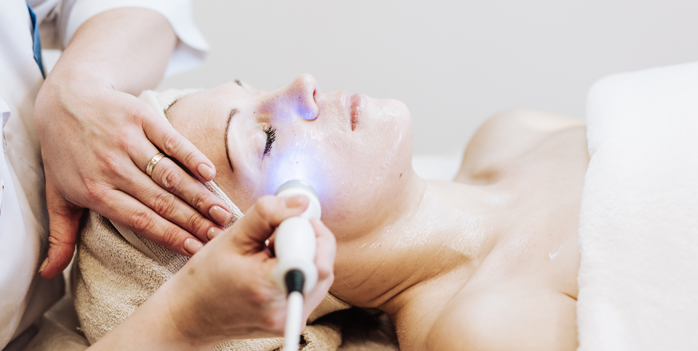 woman wrapped in a towel receiving a laser i p l treatment